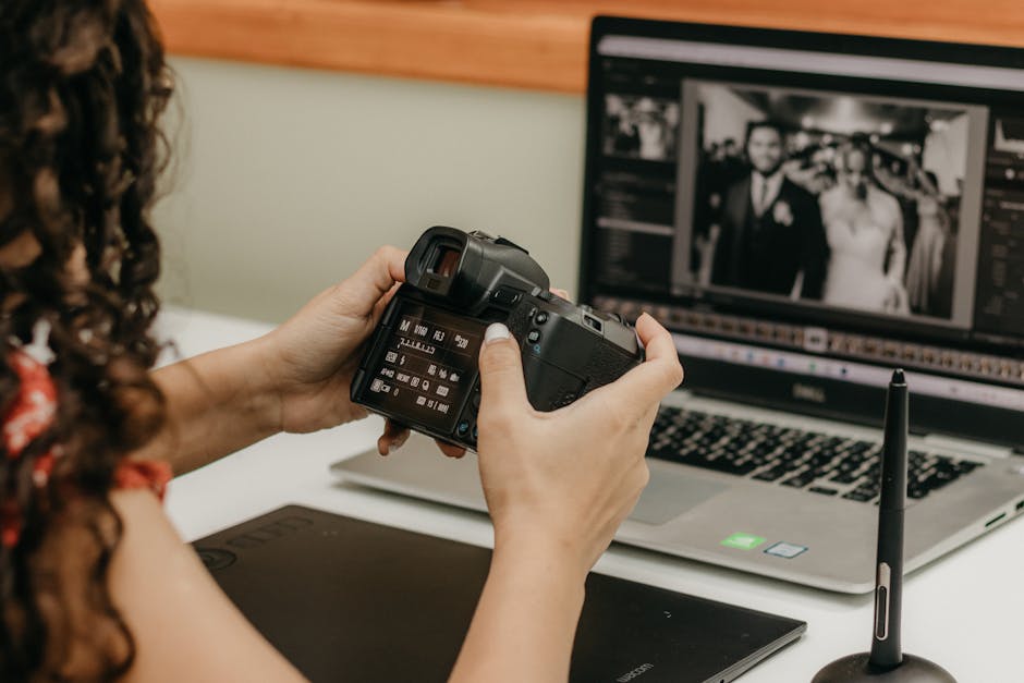 Photographer reviews camera settings while editing wedding photos on a laptop.